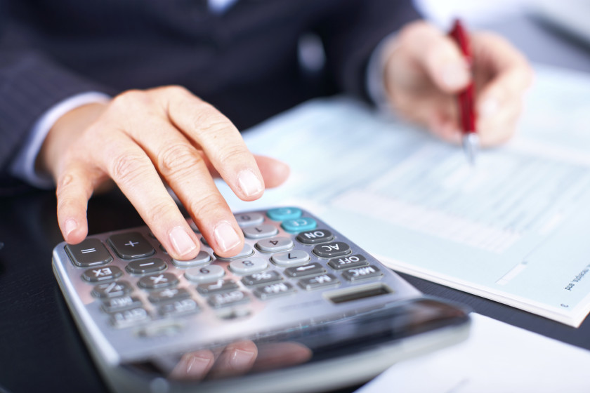 Imagem colorida de mão branca teclando calculadora