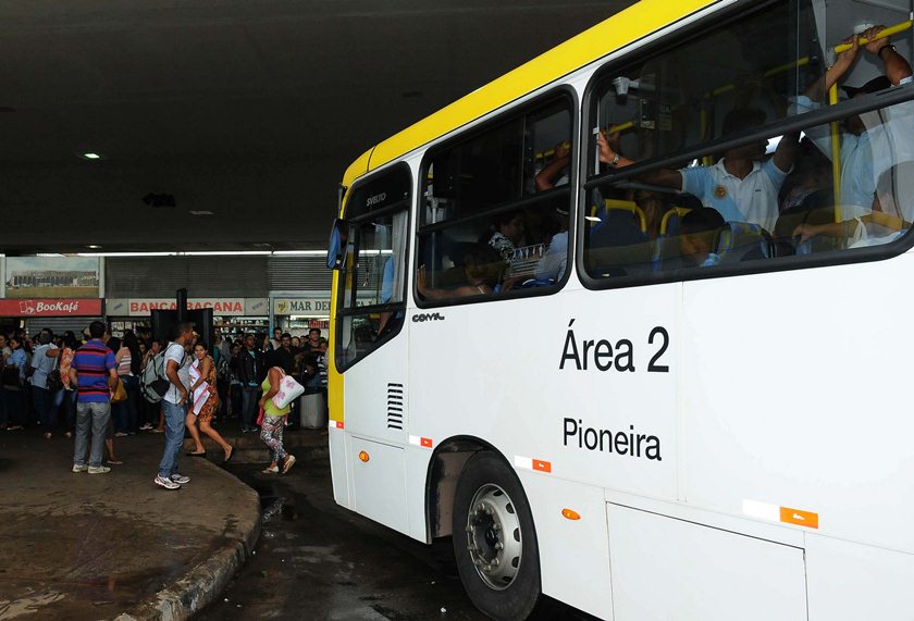 Imagem colorida mostra ônibus branco e amarelo