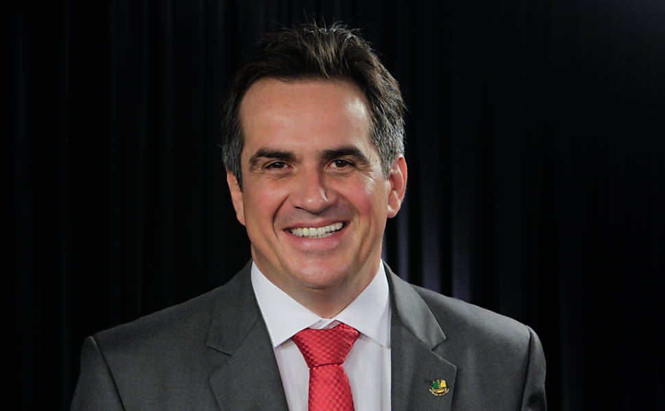 Em ambiente interno, o senador Ciro Nogueira olha para a câmera e sorri. Ele usa terno cinza e gravata vermelha - Metrópoles