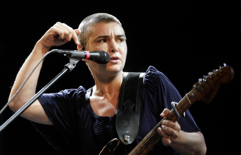 Foto colorida de Sinead O'Connor cantando