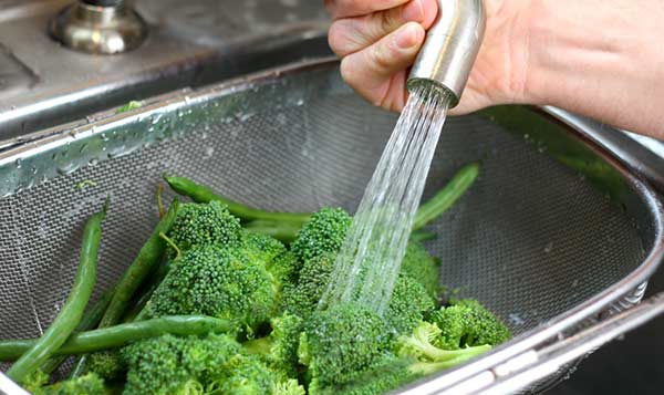 Imagem colorida de verduras sendo higienizadas - Metrópoles