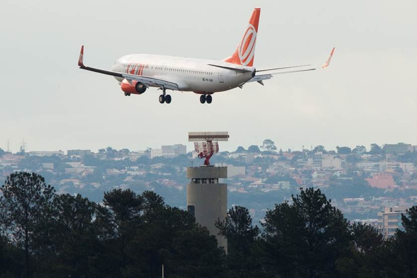 imgem colorida avião da Gol voando perto de torre de aeroporto - Metrópoles