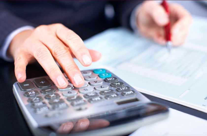 Imagem colorida de mão e calculadora - Metrópoles
