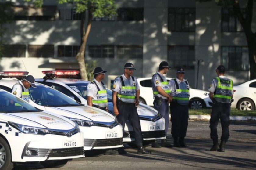 Viaturas da PMDF com policiais militares ao lado