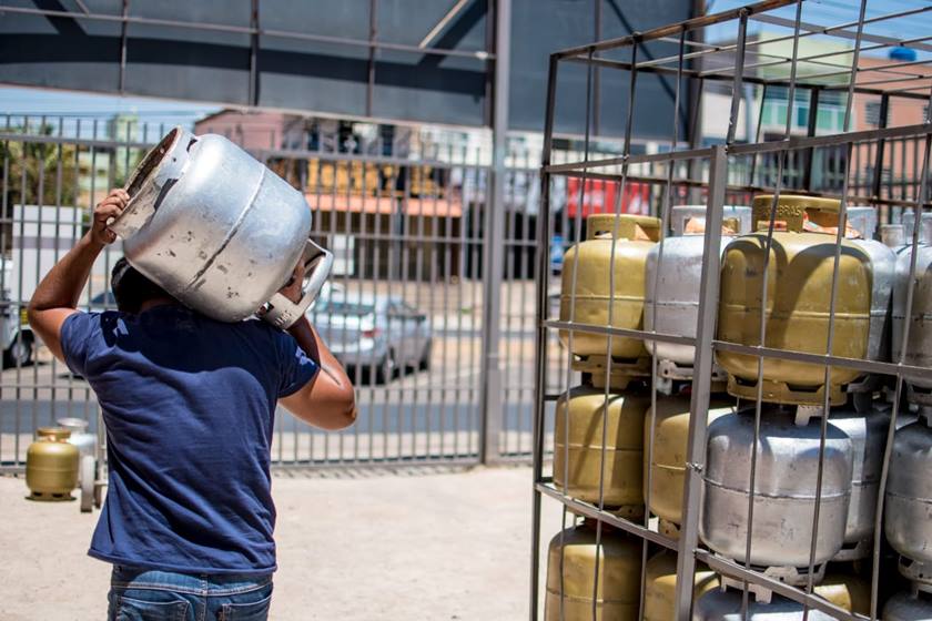 Homem carregando botijão de gás na cabeça