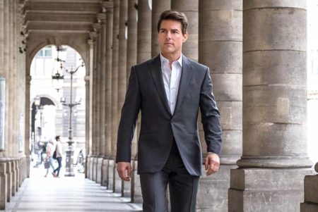 Foto colorida de Tom Cruise. O ator veste um terno e está caminhando - Metrópoles