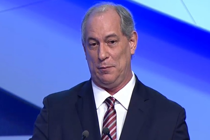 Ciro Gomes em debate da TV Bandeirantes. Ele olha para frente e fala ao microfone, sob fundo azul - Metrópoles