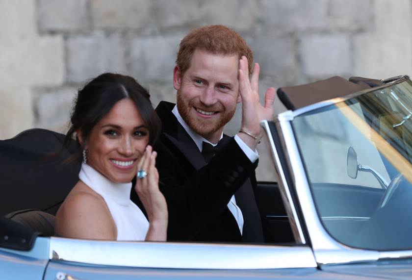 Prince Harry e Meghan Markle acenam para fãs