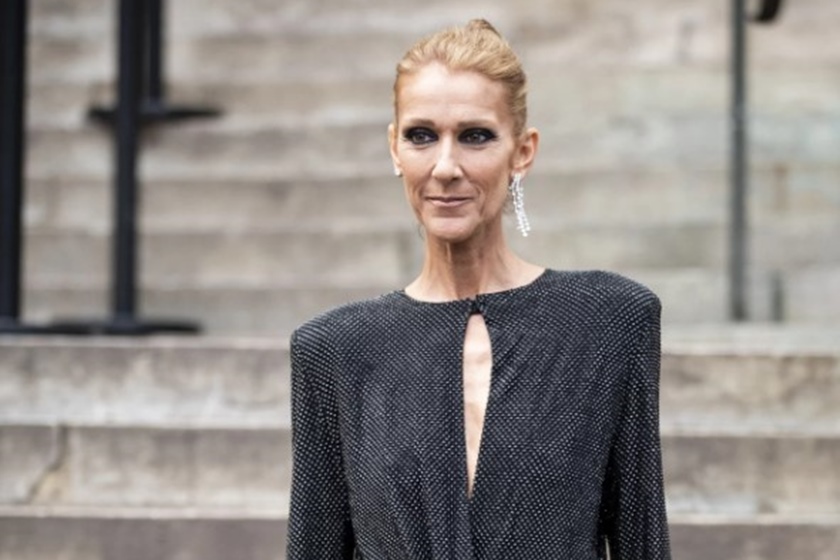 Celine Dion está com roupa preta, é branca e loira - Metrópoles