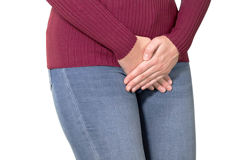 Imagem colorida de mulher tampando a parte íntima por cima da vestimenta