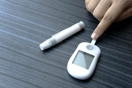 Foto colorida: pessoa posiciona dedo indicador em teste de diabetes - Metrópoles
