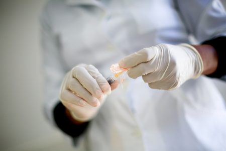 profissional de saúde manipulando vacina