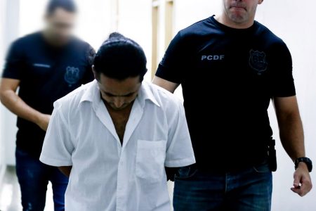 preso sendo conduzido por policiais