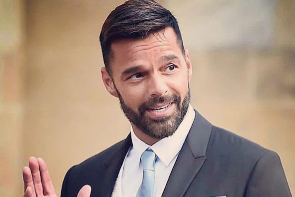 Ricky Martin veste um terno preto, com uma gravata clara. Ele é branco e tem cabelo preto - Metrópoles