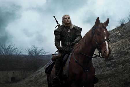 Henry Cavill com uma armadura em cima de um cavalo em The Witcher - Metrópoles