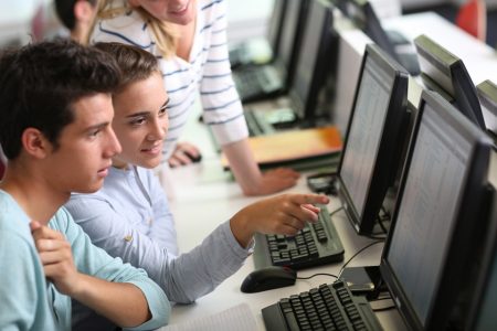 Imagem colorida de jovens em frente a computador - Metrópoles
