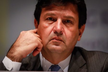 Ministro da Saúde, Luiz Henrique Mandetta com a mão direita perto do rosto
