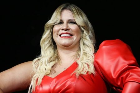 Marília Mendonça de macacão vermelho em show na cidade de São Paulo