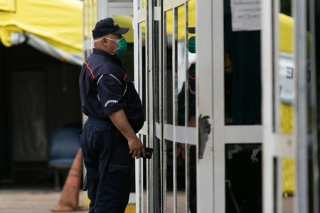 Funcionário usa máscara contra o coronavírus no Hran