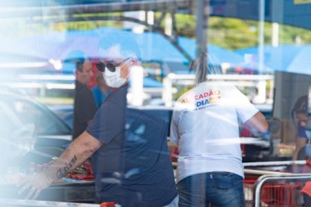 Homem usa máscara enquanto faz compras