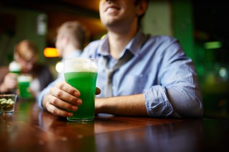 Homem segurando chope verde