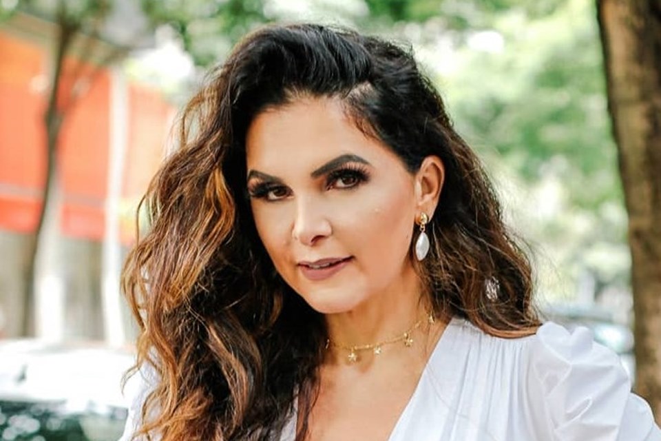 Foto de Luiza Ambiel. Ela está de blusa branca, maquiada e faz carão. Cabelos soltos - Metrópoles