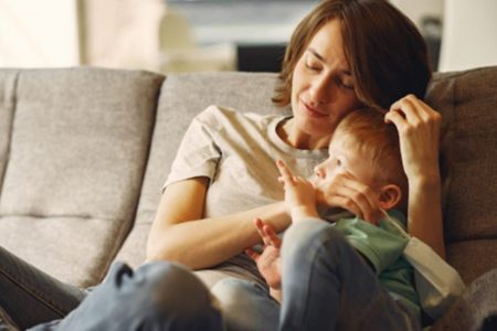 Mulher com filho e uma máscara na mão