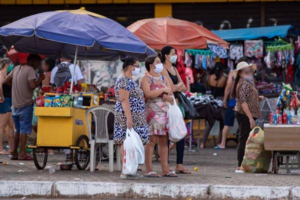 Pessoas caminham entre ambulantes no centro de Ceilândia