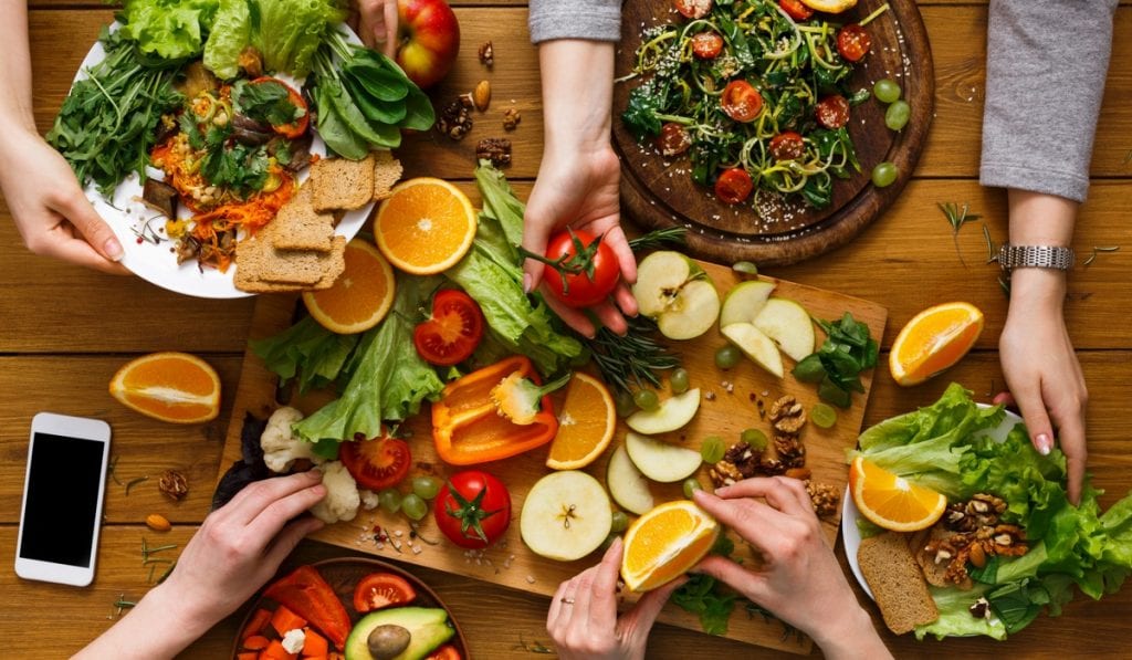 Mãos com frutas, verduras e legumes, comida vegana