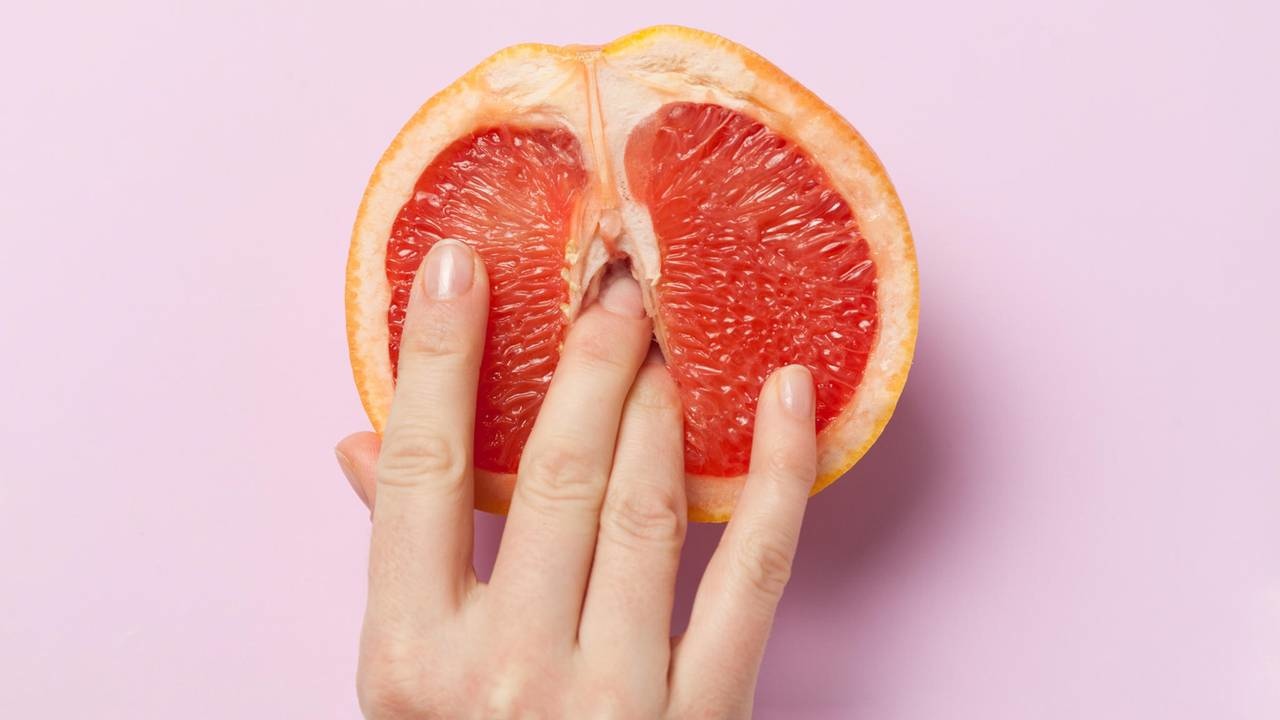 Dedos penetrando uma toranja