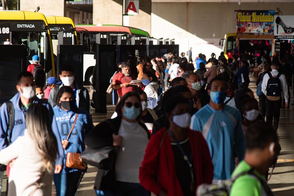 Pessoas de máscaras na Rodoviária