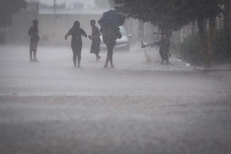 Meninos brincando na chuva no Sol Nascente