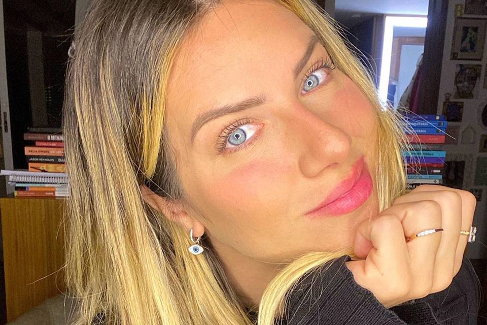 Foto colorida de uma mulher branca e loira