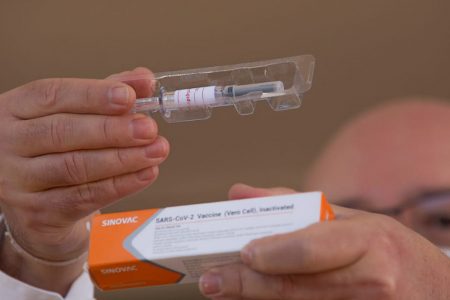 Doutor Gustavo Romero, coordenador do estudo da vacina contra Covid-19 no Distrito Federal, mostra embalagem e seringa utilizada para a imunização - vacina covid