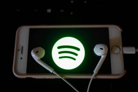 Celular com logomarca do Spotify e fones de ouvido