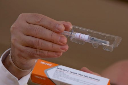 Doutor Gustavo Romero, coordenador do estudo da vacina contra Covid-19 no Distrito Federal, mostra embalagem e seringa utilizada para a imunização - vacina covid