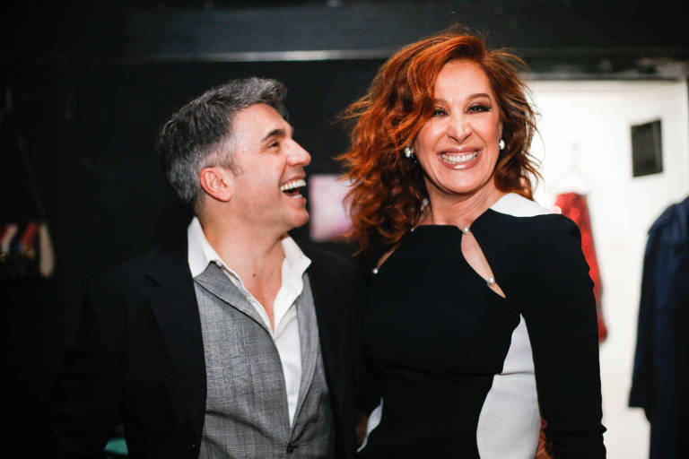 Jarbas Homem de Mello e Claudia Raia. Ele tem pele clara, cabelo curto preto com fios brancos e usa um paletó preto e uma camisa social cinza. Ela usa um vestido preto com branco, está de cabelo castanho claro solto e tem pele clara. Os dois estão sorrindo- Metrópoles