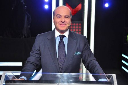 marcelo de carvalho. ele é um homem branco, careca, usa terno e gravata e está na bancada de um programa - Metrópoles