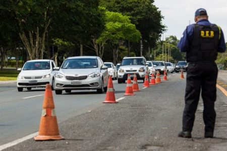 Blitz do DER com agente, cones e carros passando
