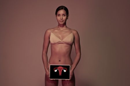 Imagem mostra mulher de sutiã com uma imagem representando seu útero em frente à barriga - Metrópoles