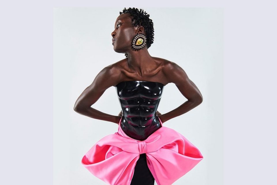 Modelo usando roupa com músculos e laço rosa - Metrópoles