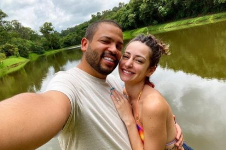 Projota e Tamy Contro. O cantor está de camisa clara, tem barba e está sorrindo. Tamy Contro está de roupa colorida, tem cabelos claros e também sorri - Metrópoles