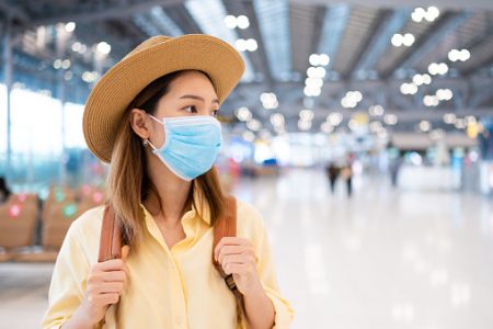 mulher usando máscara em aeroporto
