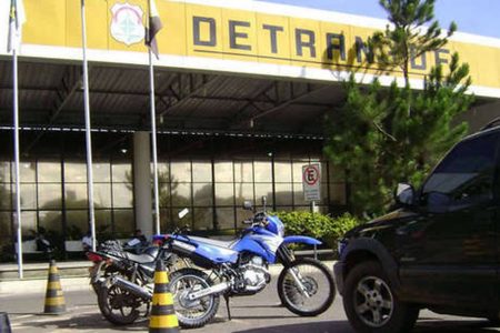 Moto azul estacionada em frente ao Detran