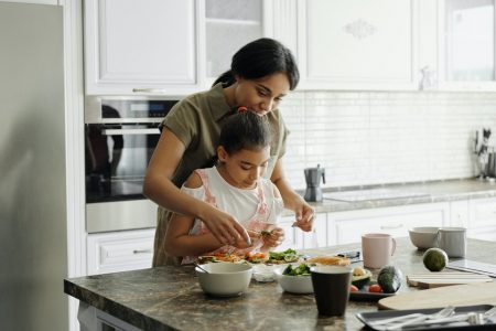 criança cozinhando com a mãe