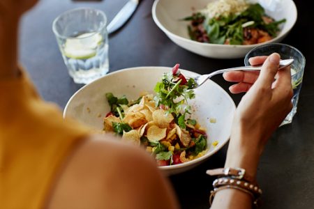 imagem colorida de mulher comendo salada - Metrópoles