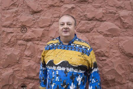 Foto colorida de Erick Jacquin apresentando o programa Pesadelo na Cozinha com roupa colorida e estampada - Metrópoles