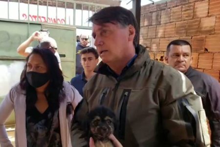 Jair Bolsonaro segura cachorro durante conversa com venezuelanas