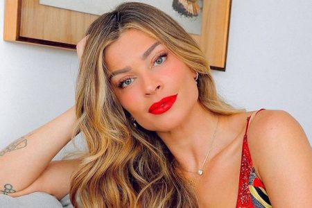 Grazi massafera sentada com cabeça apoiada no braço