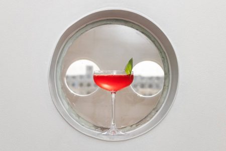 Drinque avermelhado em taça coupe